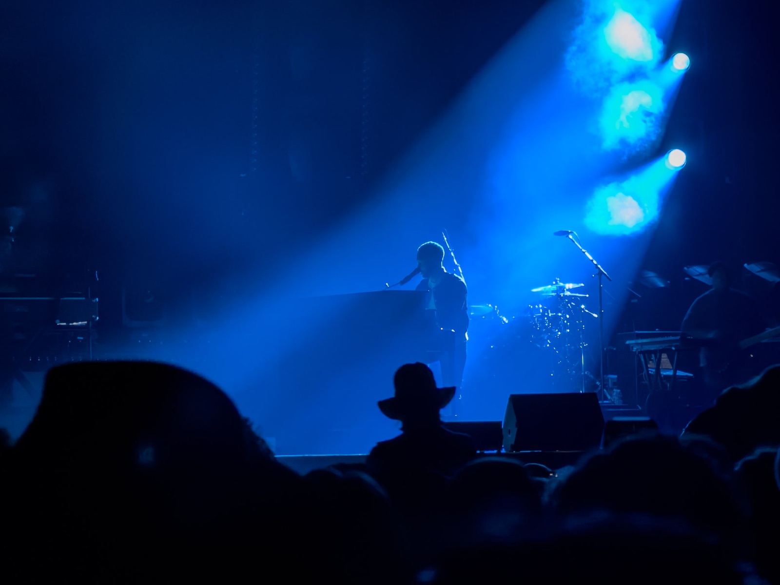 Musician John Legend performing on stage under concert lighting